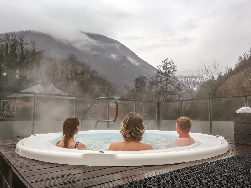 Gasten ontspannen in een bubbelbad met uitzicht op de bergen in Brides-les-Bains