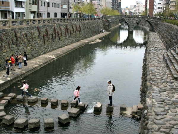 Kinderen spelen bij de oudste brug van Nagasaki