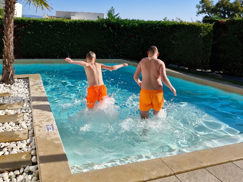 De jongens van Alma springen in het zwembad bij hun appartement van Kappa Luxury Villas & Suites op het Griekse Chalkidiki
