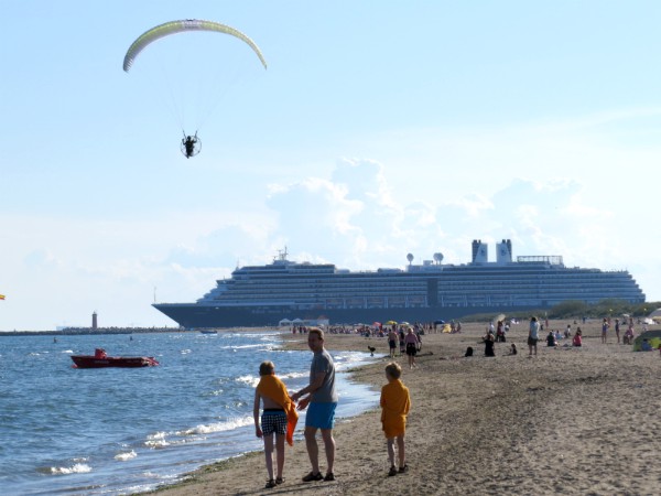 Op het strand langs de Venetiaanse kust zie je de cruiseschepen langsvaren