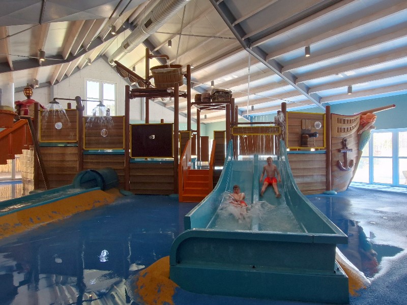 Lekker spelen in de overdekte waterspeeltuin met glijbanen van strandpark De Zeeuwse Kust