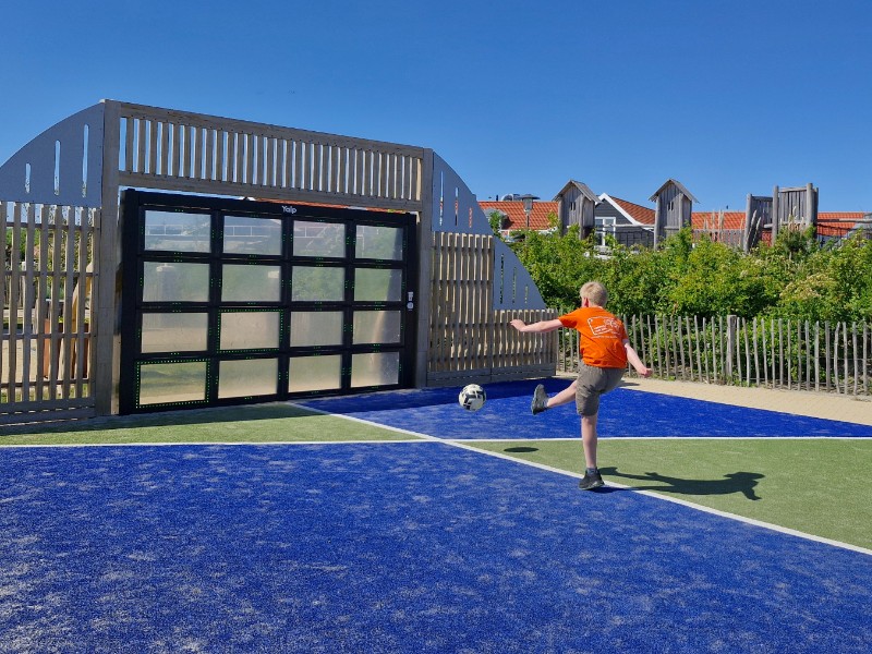 De kinderen van ALma trappen tegen een balletje op één van de sportveldjes van Strandpark de Zeeuwse Kust in Renesse