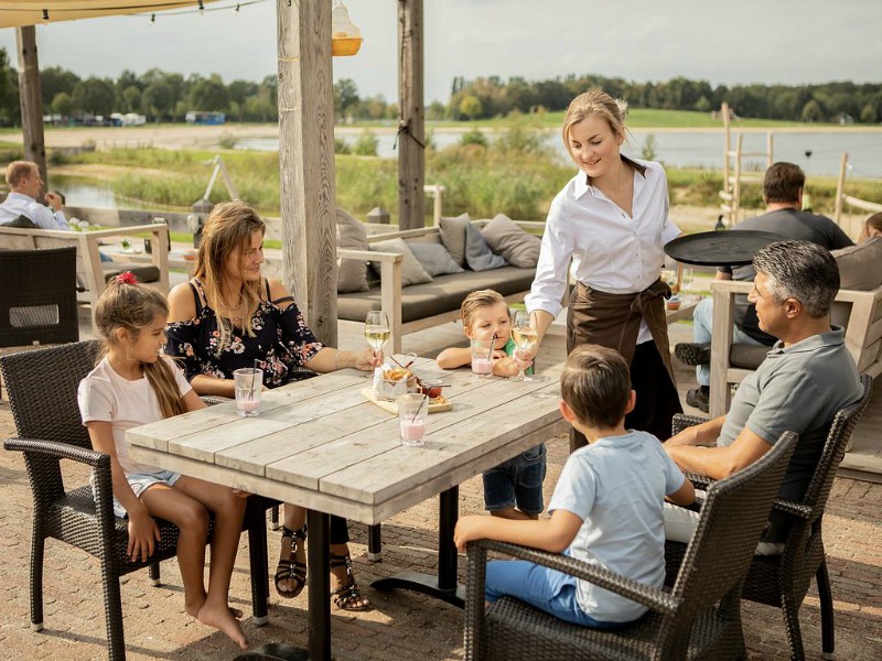 Terras met speeltuin ervoor en zicht op het meer