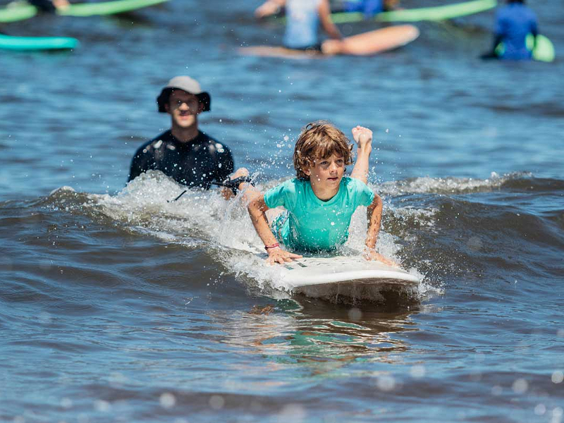 Jongen aan het surfen tijdens een Juniorcamp voor kids van 12-16 jaar.