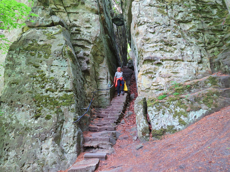 Sabine wandelt door de spleet in de rotsen van de Teufelsschlucht