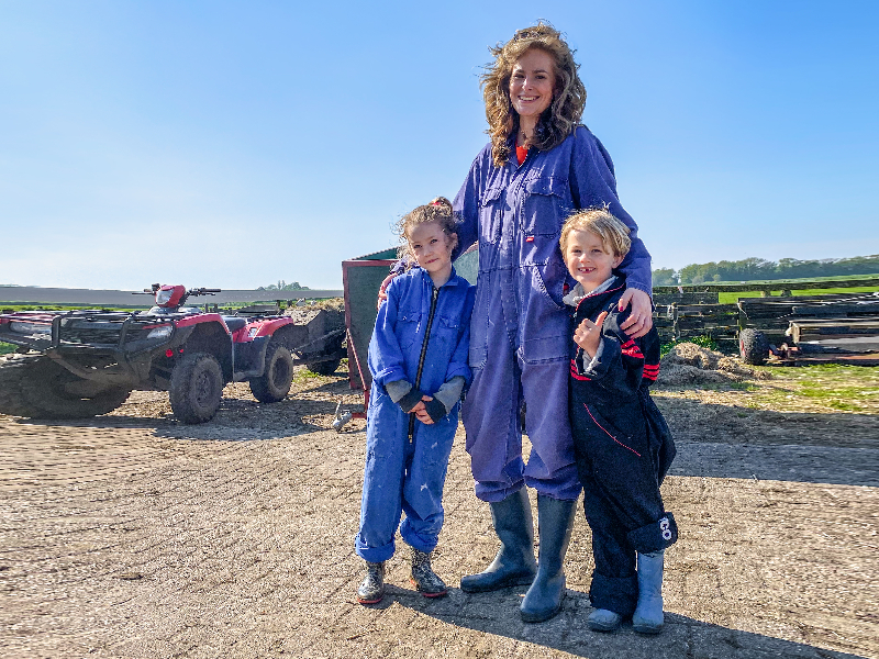 Elisabeth en haar kinderen in overalls van schapenbedrijf de Waddel op Texel