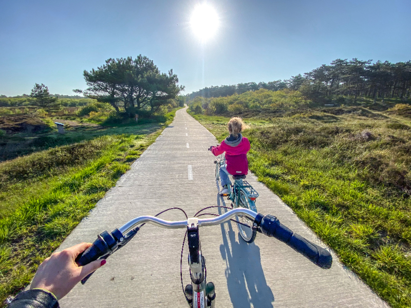 Elisabeth en haar dochter fietsen door de duinen in het Zuiden van Texel naar het strand