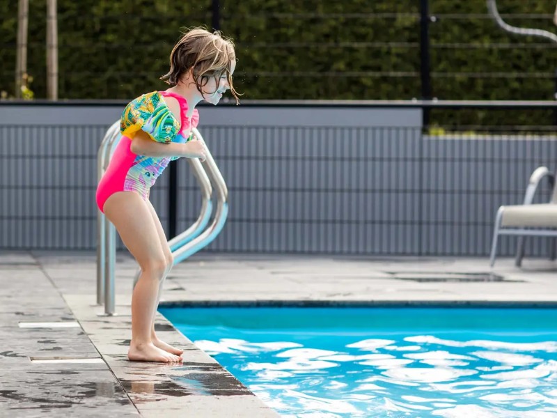 Een kind staat klaar om in het zwembad te duiken op vakantiepark Beekbergen in de Gelderse Veluwe