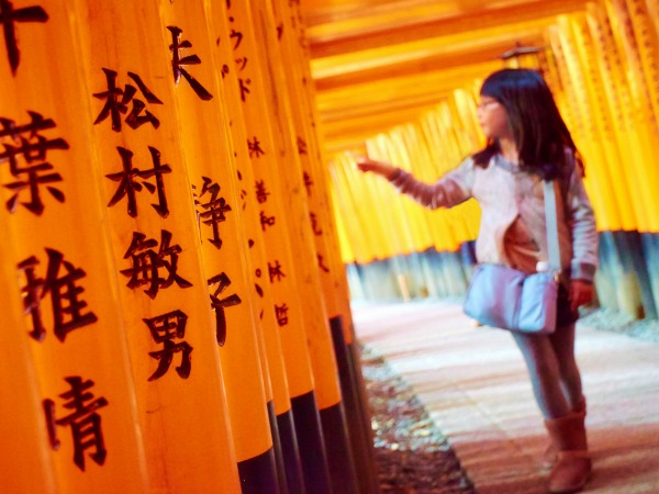 Meisje telt de Torii gates in de beroemde Torii galerij in Kyoto