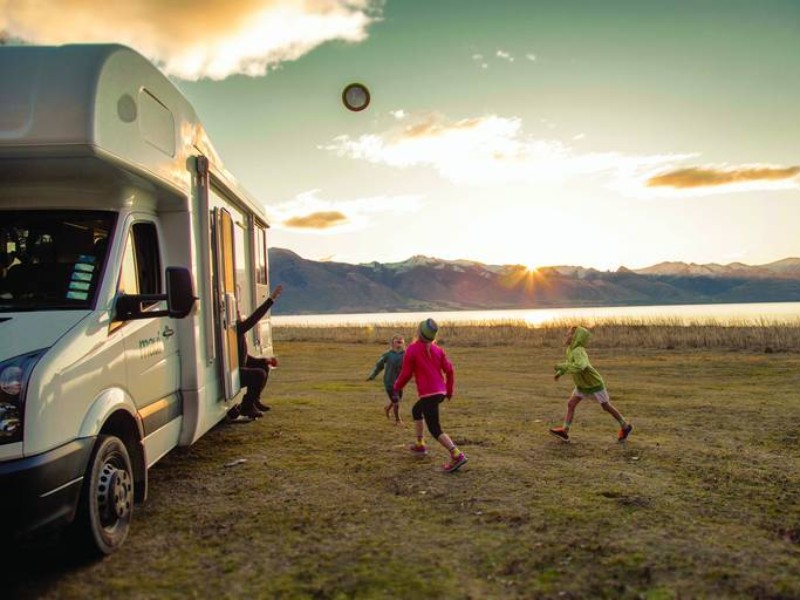 kinderen spelen voor de camper