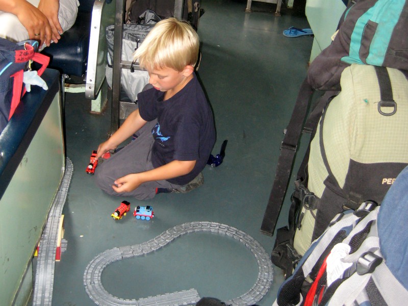 Tycho bouwt een treinbaan in het gangpad van de trein..