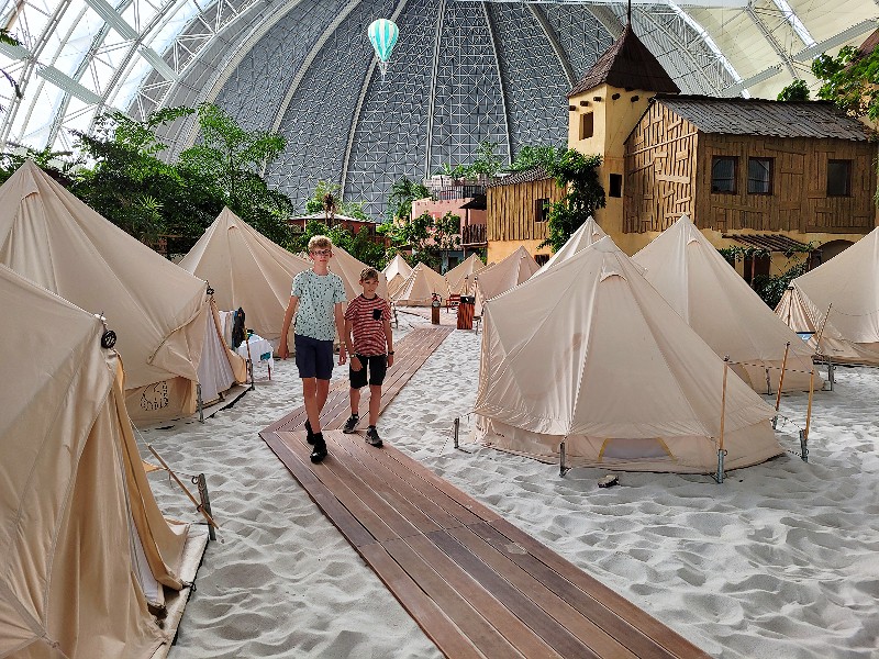 Zeb en Tycho lopen tussen de tenten van Tropical Islands