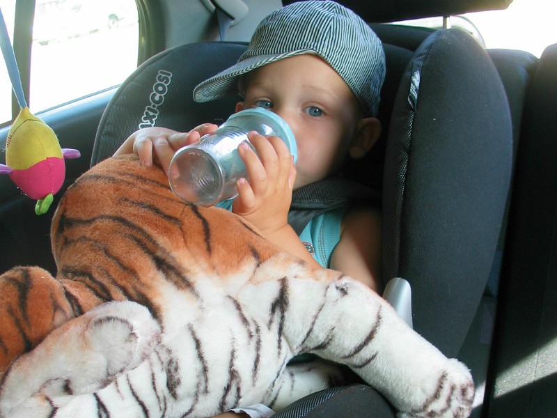 Baby Tycho met flesje in de autostoel