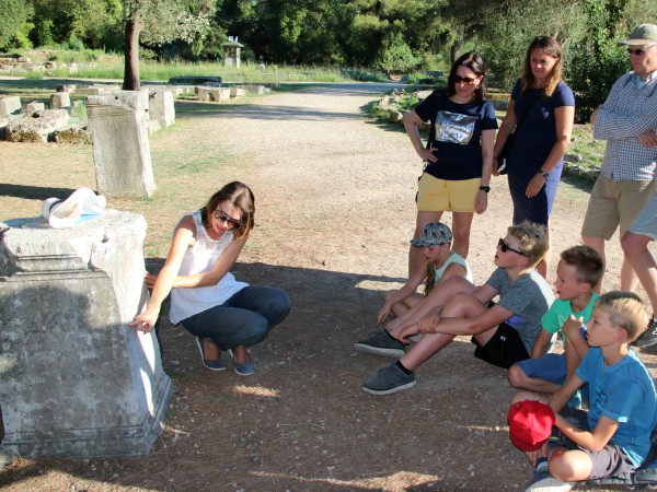 De kinderen krijgen uitleg van onze gids bij de ruïnes van Olympia