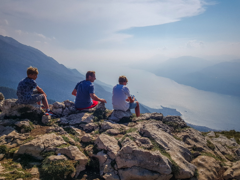 Patrick en de kinderen kijken uit over het Gardameer tijdens onze vakantie in Italie