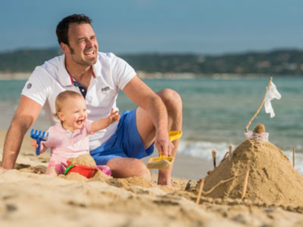 Vader met baby op het strand