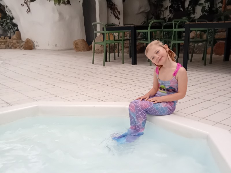 De dochter van Emma in het ondiepe badje voor peuters