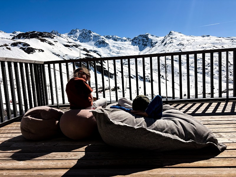 Seppe en Bobbie genieten op het dakterras van de besneeuwde bergen