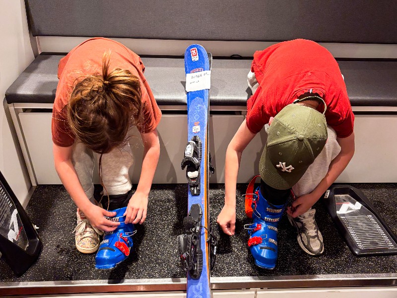 Seppe en Bobbie passen de skischoenen bij het verhuurbedrijf