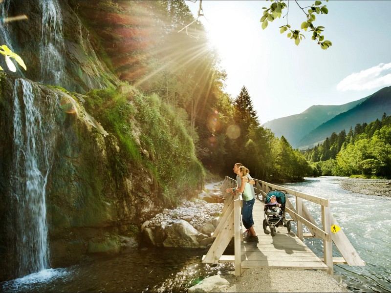 Gezin bij de waterval op de brug