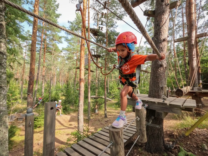 Enthousiast klimmen de kinderen van Lisette over de verschillende parcoursen van Vimmerby Adventure
