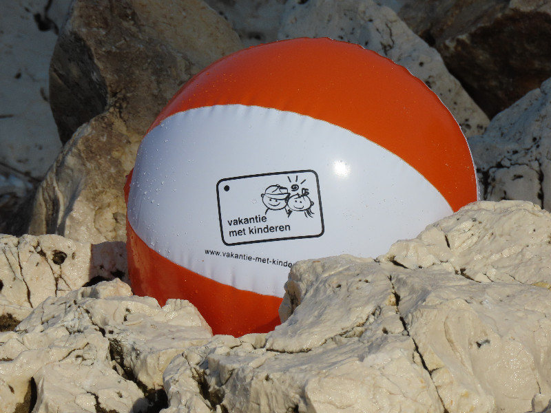 Strandbal van Vakantie met Kinderen op de rotsen van het strand op Corfu