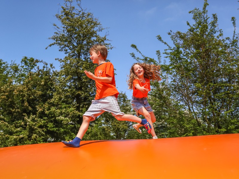 De kinderen van Elisabeth springen en spelen in het speeltuintje op het strandje bij de safaritent. 