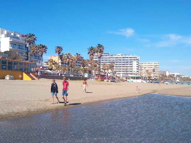 Zeb en Tycho wandelen over het strand van de Costa del Sol