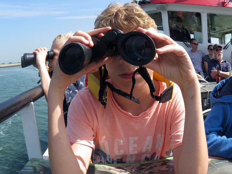 Zeb speurt met een verrekijker naar de zeehonden