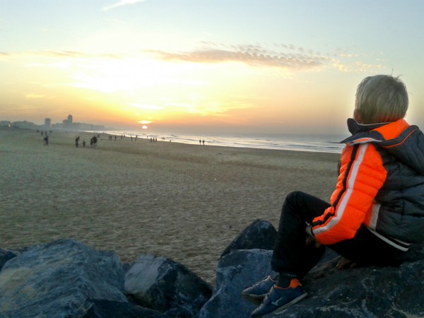 Tycho kijkt naar de zonsondergang aan het strand van Oostende