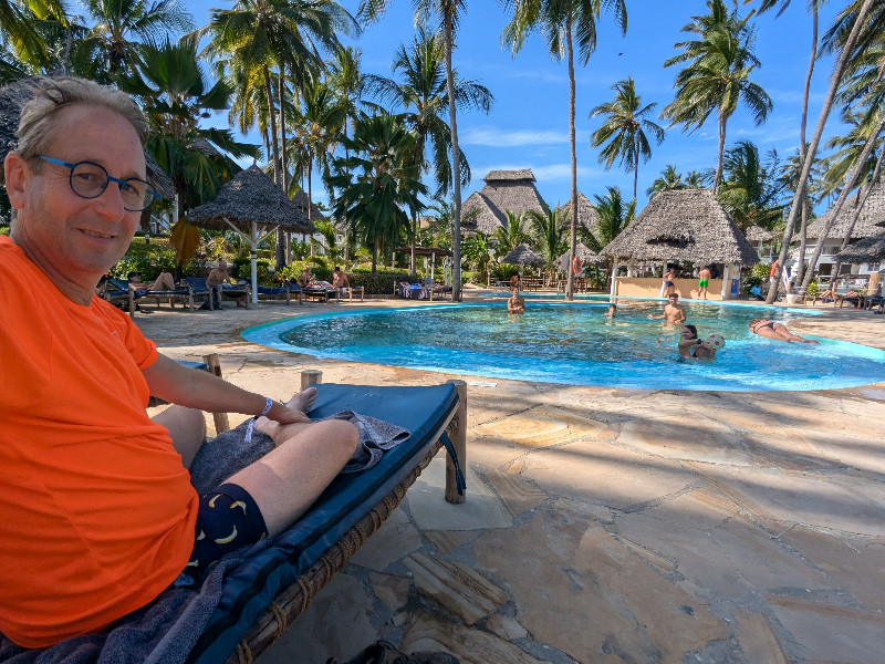 Patrick bij het zwembad bij het hotel op Zanzibar