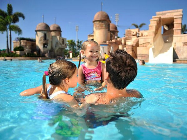 Vader met twee dochters aan het zwemmen in het zwembad van een hotel bij de Amerikaanse pretparken.